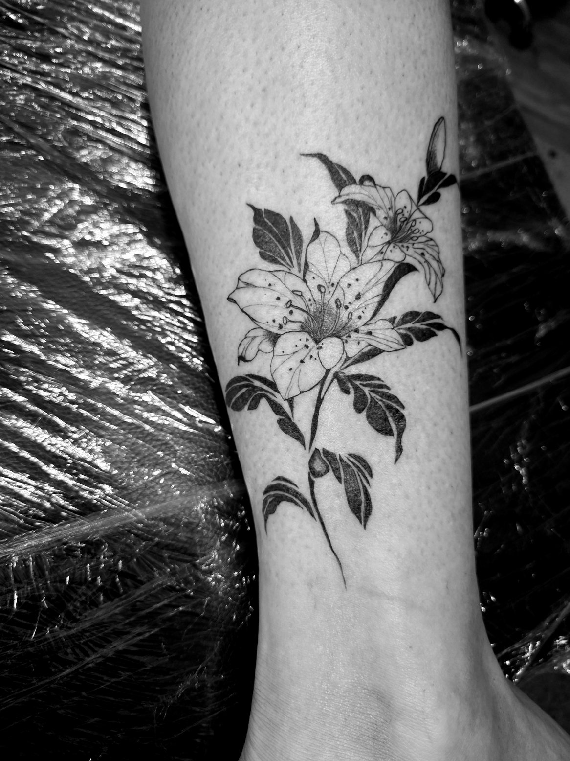 Florales Fineline Tattoo am Unterarm in Schwarz-Weiß