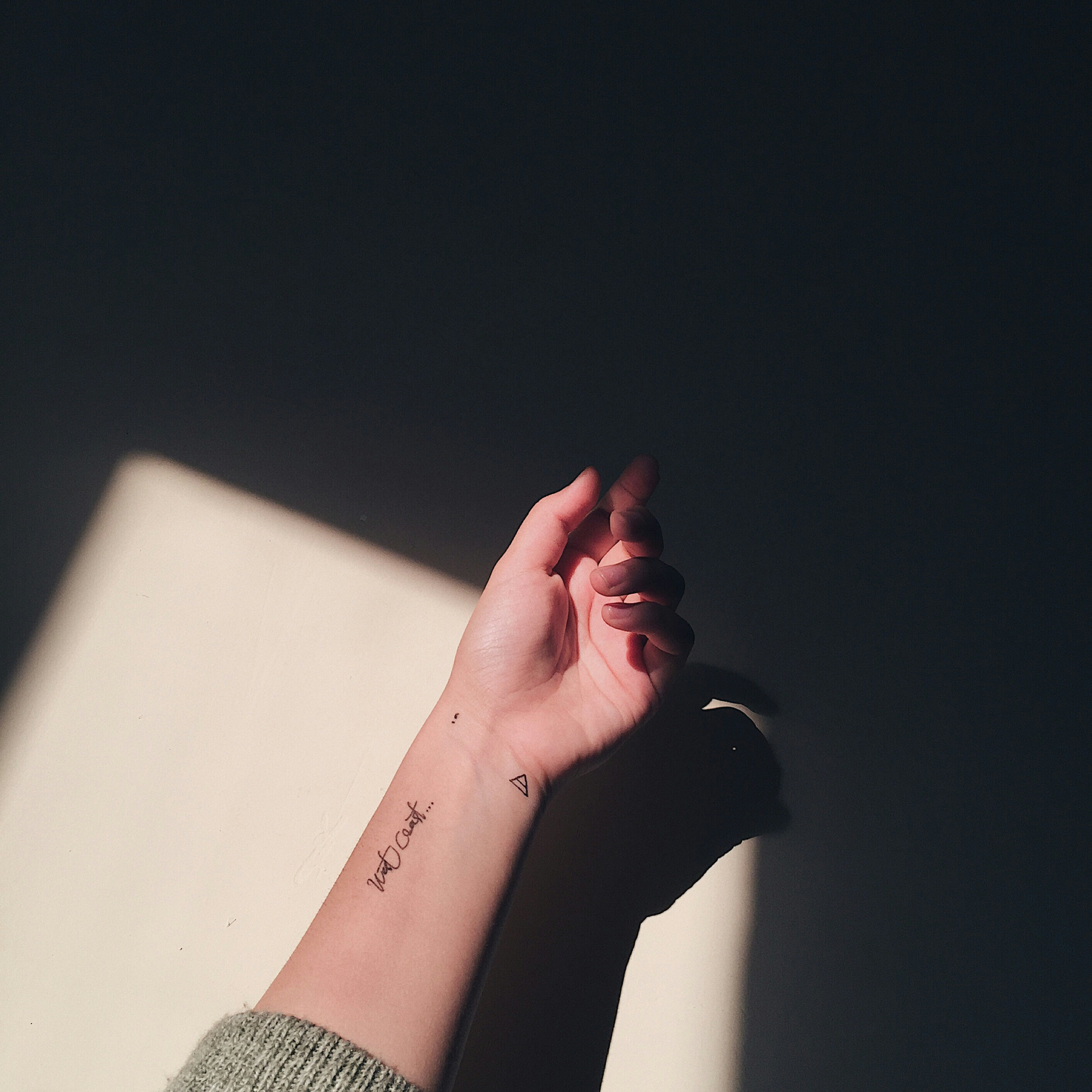 Image of hand with small fineline tattoos